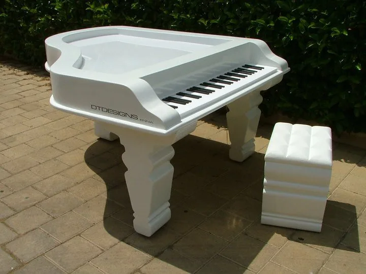 Un pianoforte fuori dagli schemi. — Un elemento scenografico a forma di pianoforte, con superfici decorate e dettagli luminosi.
